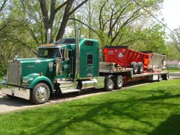 step deck load on green truck.